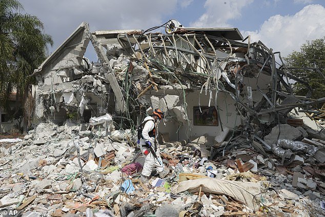 An Israeli soldier walks past a house destroyed by Hamas militants in Kibbutz Be'eri, Wednesday, October 11, 2023