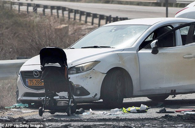 Cars and a stroller left at the scene of a rocket attack from Gaza at the weekend are pictured on a main road near the entrance to the Israeli kibbutz of Kfar Aza.