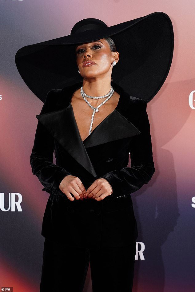 In style: Sports commentator Alex made sure she stood out from the crowd in a chic black trouser suit and huge oversized hat which ensured all eyes were on her
