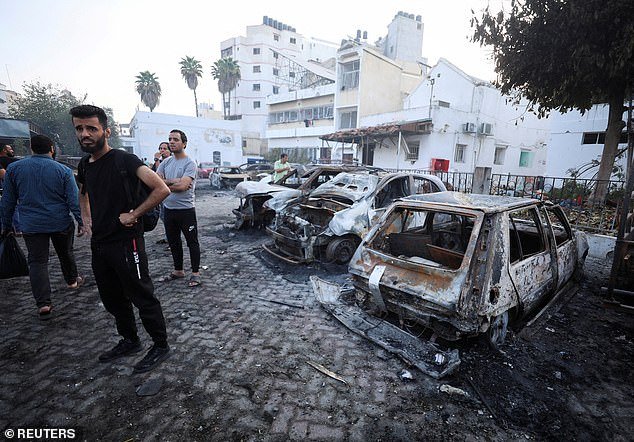 People inspect the area of ​​Al-Ahli Hospital where hundreds of Palestinians were killed in an explosion that Israeli and Palestinian officials blamed on each other