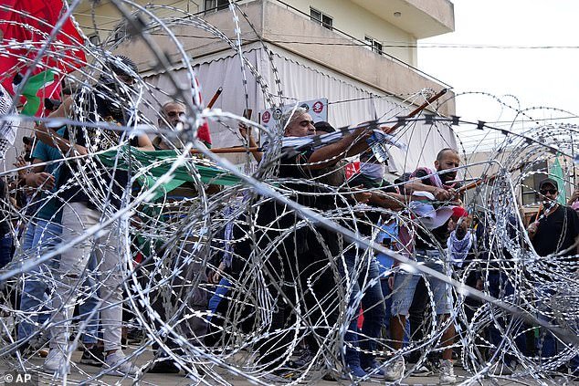 Protesters attempt to remove barbed wire blocking a road leading to the U.S. Embassy in Beirut, Lebanon