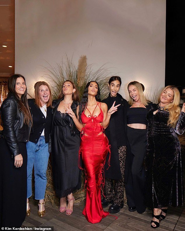 Kim flashed two peace signs as she was surrounded by friends during the festivities