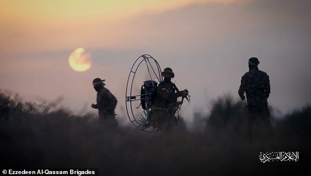 Hamas fighters from the 'Falcon' squadron were seen walking through the sand at dawn carrying the equipment to be used in the operation