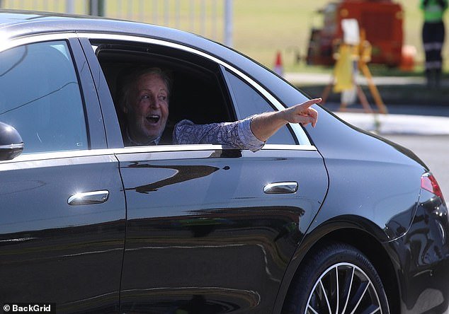 Upbeat: The legendary musician appeared to be in an excited mood as he greeted onlookers with a series of cheerful waves as he drove through the eastern Australian city