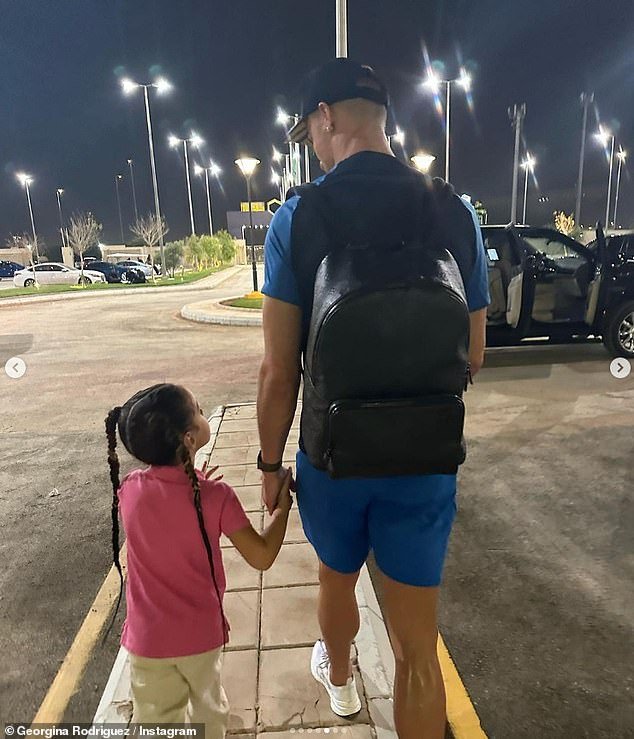 Doting dad: Georgina shared a sweet photo of the footballer and his daughter as they walked hand in hand