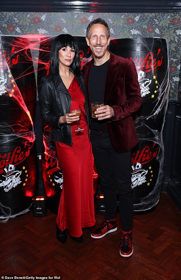Strike a pose: Television presenter Andrea McLean looked ravishing in a red dress and black wig as she stood next to her husband Nick Feeney