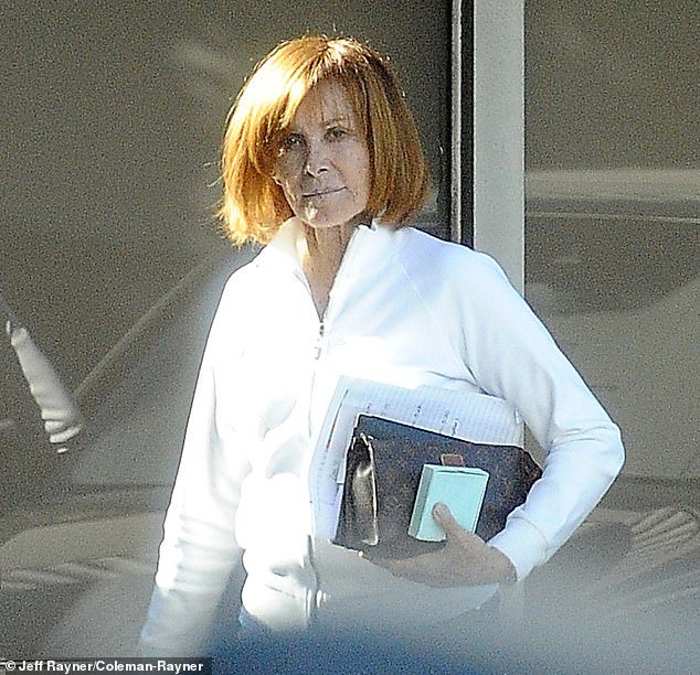 Powers emerged from an LA office building with some papers and her Louis Vuitton bag in her hand