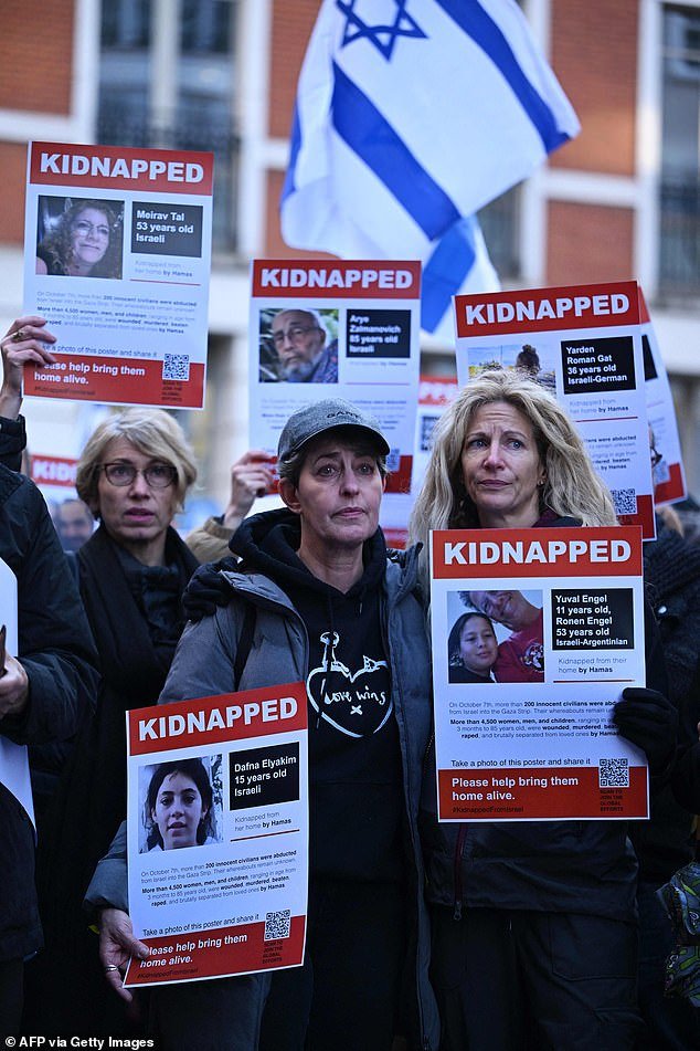 Posters featuring kidnapped Israeli Dafna Elyakim and Israeli-Argentinians Yuval and Ronan Engel are seen as people gather outside the Qatari embassy in London on October 29, 2023