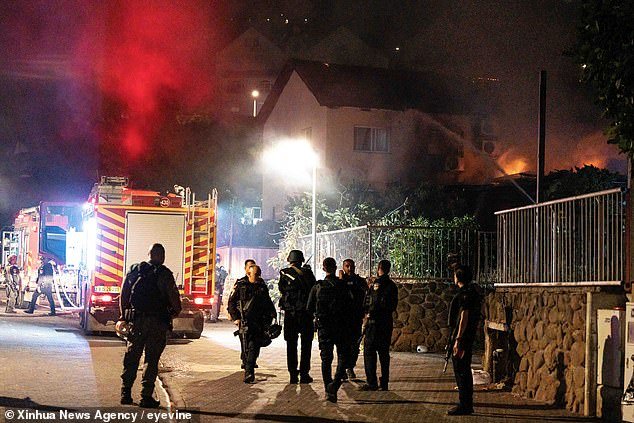 Hamas terrorists attacked Israel earlier this month, leading to the largest single-day massacre of Jewish people since the Holocaust.  So far, 1,400 Israelis have been killed in the conflict.  Pictured: Israeli security forces and emergency services stand guard in the northern Israeli town of Kiryat Shmona after being hit by a rocket from Lebanon on October 29