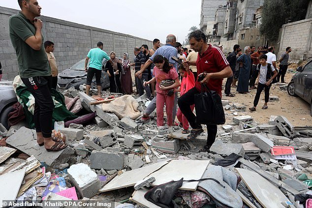 Democrats have called for an Israeli ceasefire after the Jewish state launched counterattacks that killed thousands of people in Gaza.  Pictured: Palestinians inspect the destroyed house after an Israeli airstrike on Rafah in the Gaza Strip