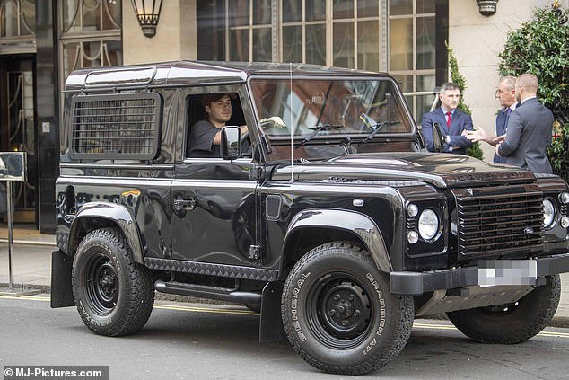 Behind the wheel: Brooklyn Beckham was at a loss as he drove his father David's prized black Land Rover Defender around London on Thursday