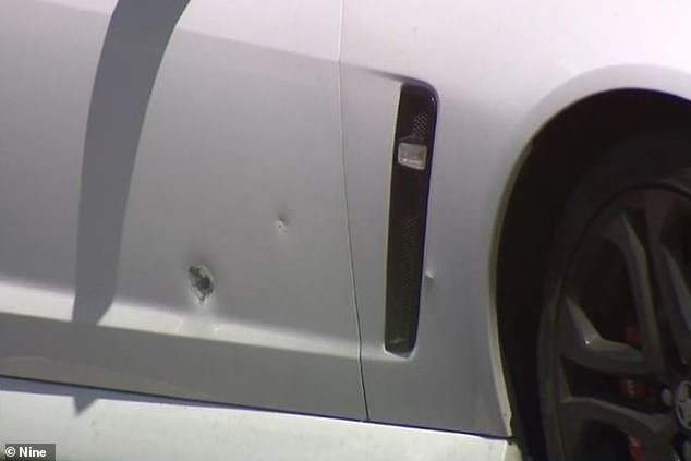 The couple were in a white Holden Commodore when two gunmen in another vehicle allegedly shot their car with bullets (pictured)