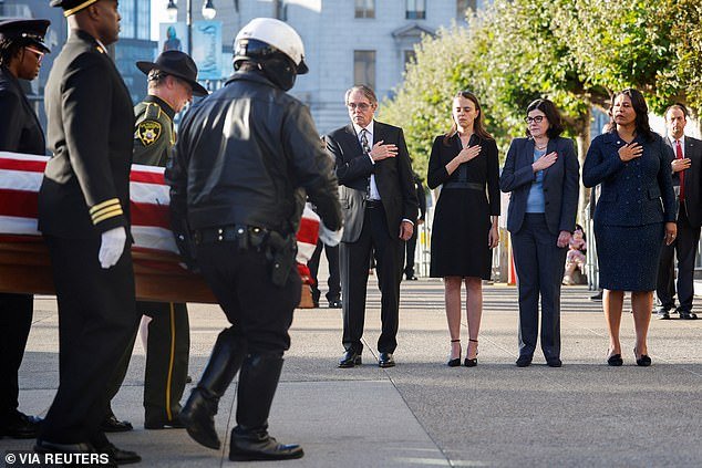 Dianne Feinstein's son-in-law Rick Mariano, granddaughter Eileen Marian, daughter Katherine Feinstein and San Francisco Mayor London Breed hold hands as the late senator's casket is carried to San Francisco City Hall to lie in state Wednesday