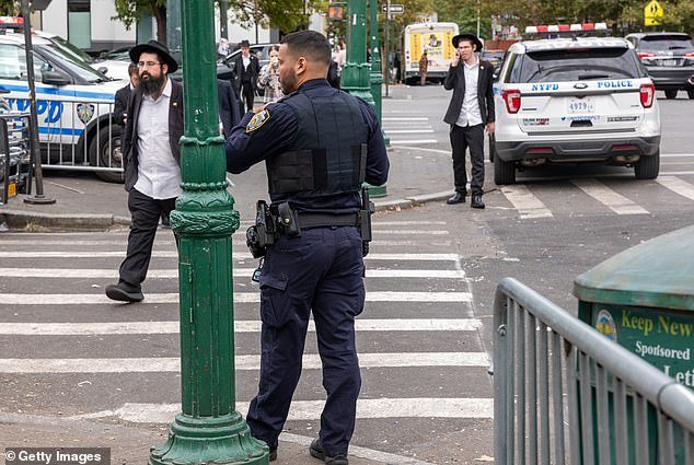 Police patrol a neighborhood in Brooklyn with a large Orthodox Jewish community on Thursday.  New York City leadership has stepped up security ahead of expected protests