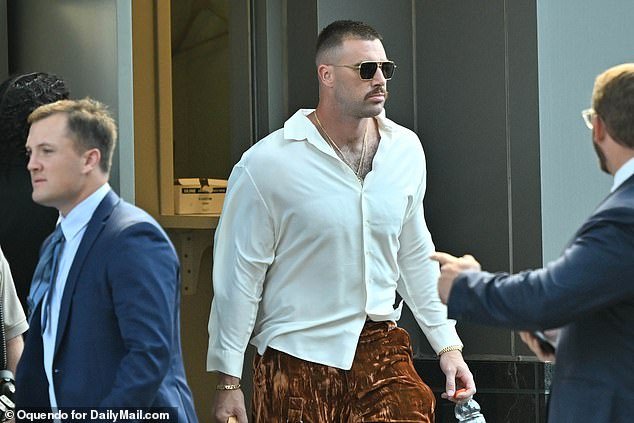 Travis Kelce wore a white silk shirt and brown velvet pants on Sunday.