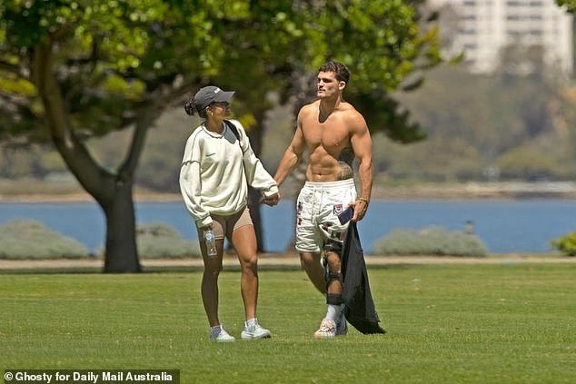 The couple were seen holding hands, laughing, chatting and cuddling in a park overlooking the water near Perth's CBD