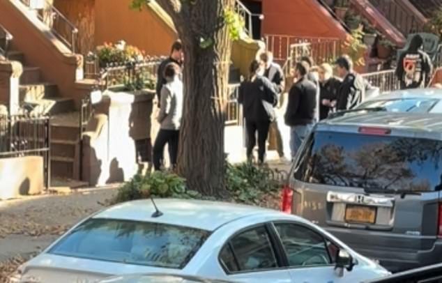 Officers are shown outside Suggs' home in Crown Heights on Thursday after the raid