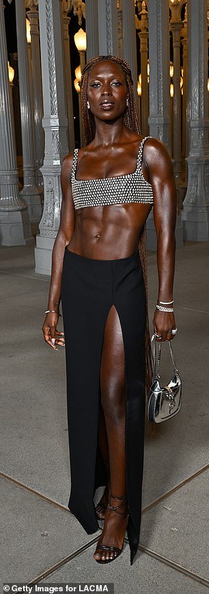 Incredible: The White Noise actress, 37, showed off her washboard abs in a silver chainmail bra, paired with a black maxi skirt with a daring thigh-high slit