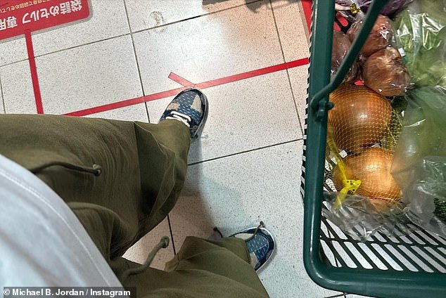 Stocking up: He appeared to have several types of onions and some greens in a shopping cart as he stocked up on a home-cooked meal, and he pointed his phone down to capture the food and a photo of his sneaker-clad feet