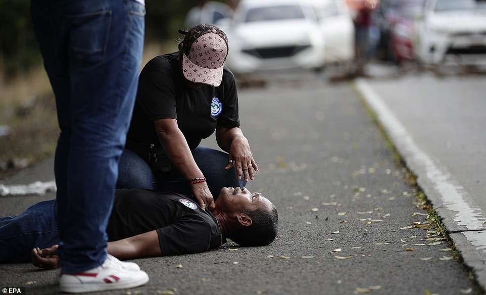 A protester is seen on the ground after being shot by a man in the middle of a teacher's blockade on the Pan-American Highway