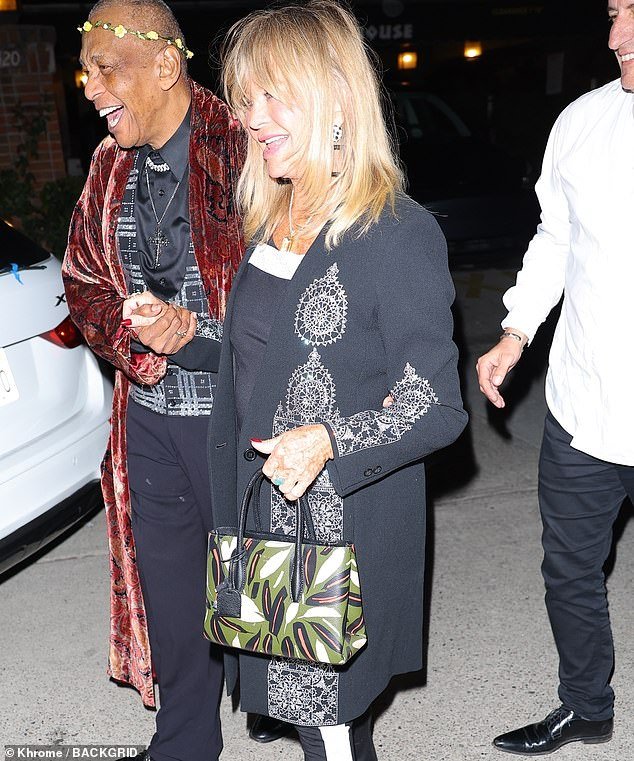 Smile: Goldie was accompanied by a friend when she arrived at the soiree
