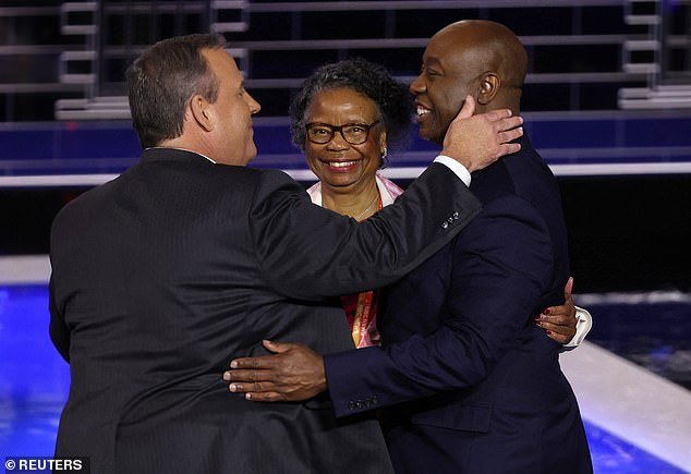 Former New Jersey Governor Chris Christie talks with US Senator Tim Scott (R-SC) and his mother Frances after the third Republican debate