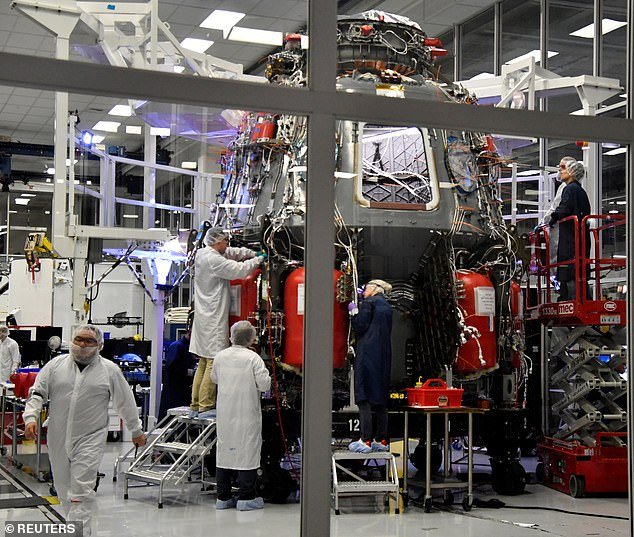 SpaceX engineers work on the Crew Dragon Demo-2 craft at SpaceX Headquarters in Hawthorne, California.  There is virtually nothing painted yellow in sight