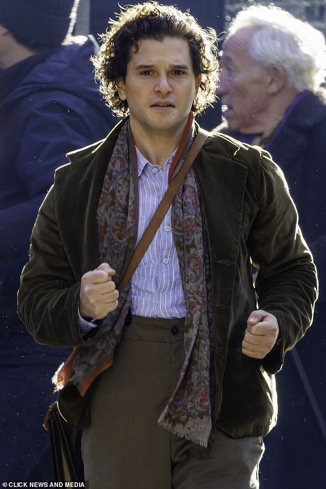 Vintage: Kit, who plays the character Virgil, wore a khaki velvet jacket with a vintage floral scarf, paired with a striped blue and white shirt
