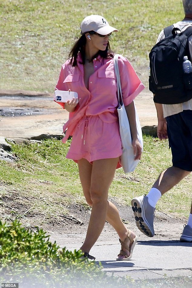 She had arrived earlier at the beach wearing a loose pink shirt dress and a cotton tote bag