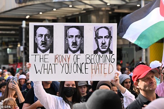 A protester in Brisbane holds a sign comparing Israeli Prime Minister Benjamin Netanyahu to Adolf Hitler