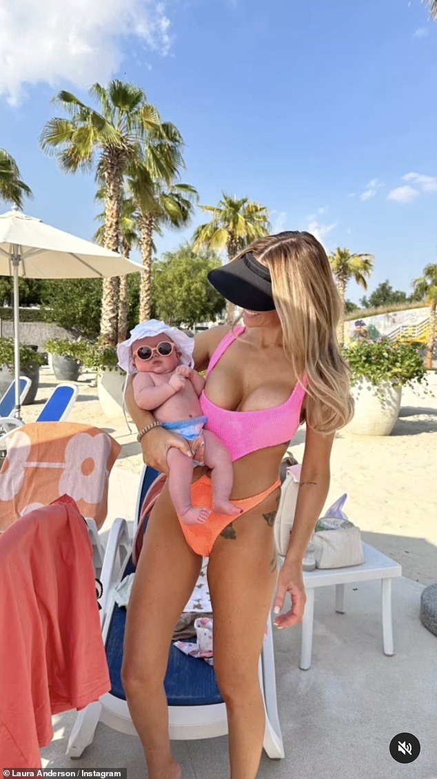 Looking good: Laura looked fantastic in a bright pink and orange swimsuit with cutouts as she cradled Bonnie, who wore a tiny sun hat and tiny sunglasses