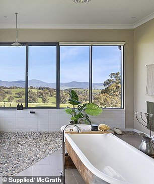 The glittering reflection of Lake Eildon is visible from the terrace of the house