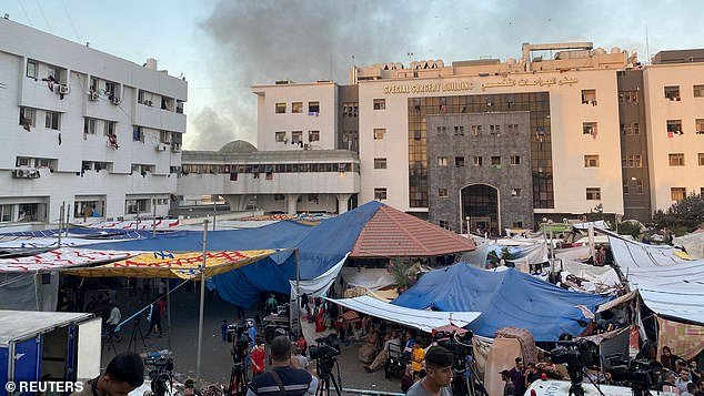 Smoke rises as displaced Palestinians take shelter in the Al Shifa landlady after the IDF invaded the building this morning