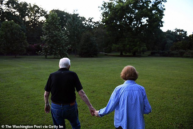 Former President of the United States, Jimmy Carter walks with his wife, former First Lady, Rosalynn Carter to their home after dinner at a friend's home on Saturday, August 4, 2018 in Plains