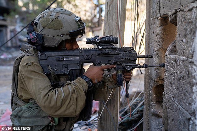 An Israeli soldier takes position in a location identified as Gaza as troops begin a ground invasion of the Strip, as seen in a handout released on November 21.