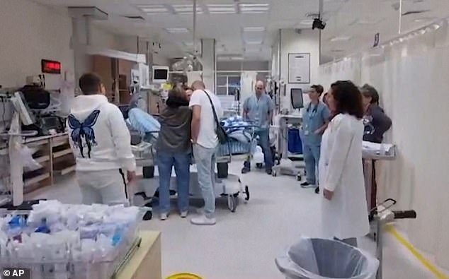 Medical staff watch as Maya hugs her family members prior to surgery