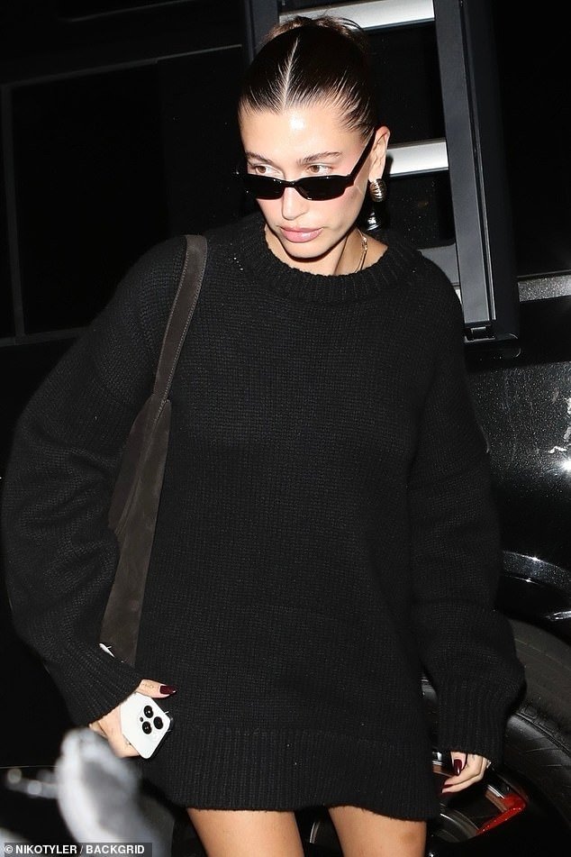 For their midweek worship, Hailey rocked an oversized black knit sweater dress that showed off her legs