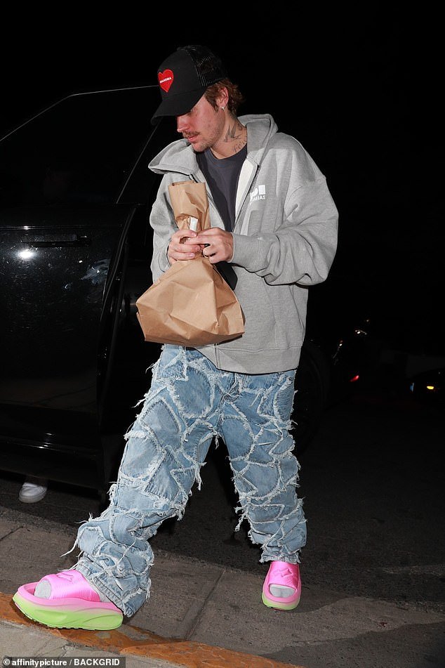 Justin arrived with a brown paper bag that appeared to contain a large, slender object