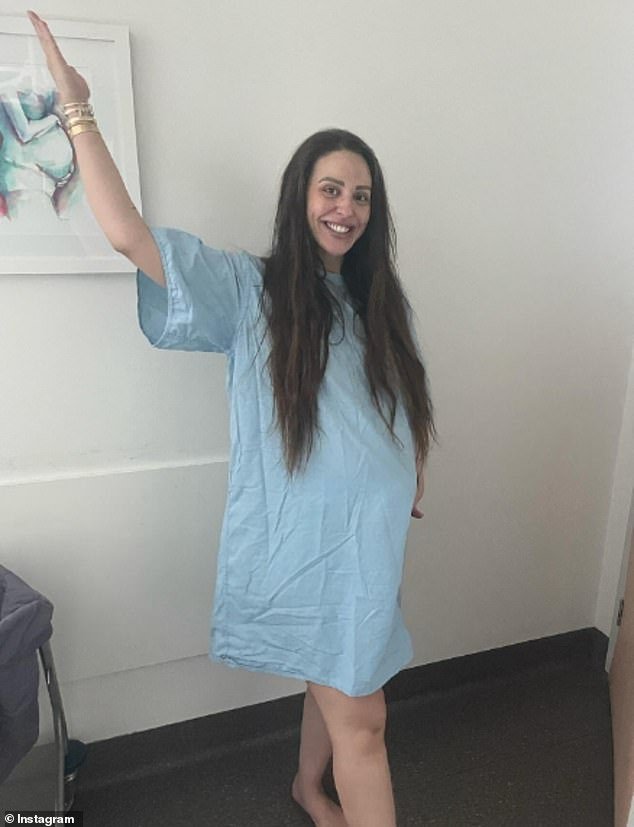 Completely make-up free, Lizzie beamed as she posed in a blue hospital gown