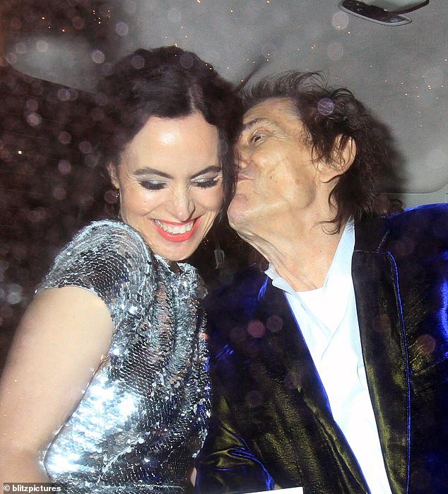 Elsewhere, Ronnie Wood, 76, couldn't keep his hands off his wife, Sally Humphreys, as he gave the 45-year-old a cheeky hug on the cheek in the back of the car