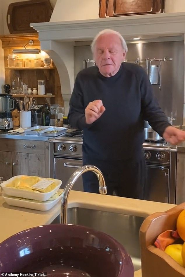 Busting his moves: Sir Anthony Hopkins, 85, showed off his 'Sunday vibe' and danced along to Mambo Italiano (1954) while cooking in his kitchen