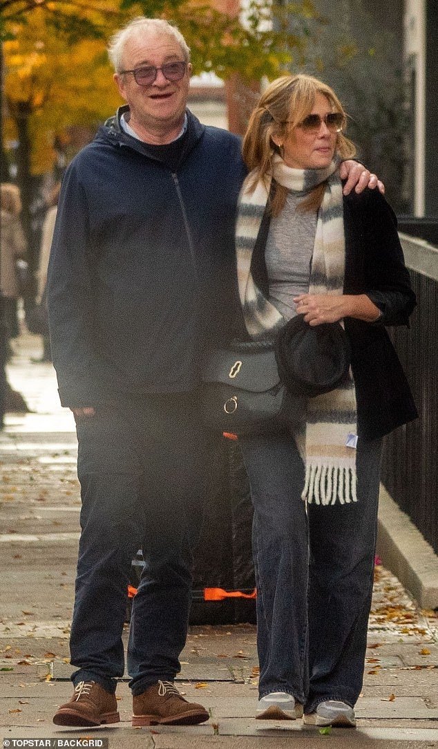 Love: Harry Enfield, 62, and girlfriend Catherine Shepherd, 48, put on a loving display while shopping for home furnishings on Tottenham Court Road in London on Sunday