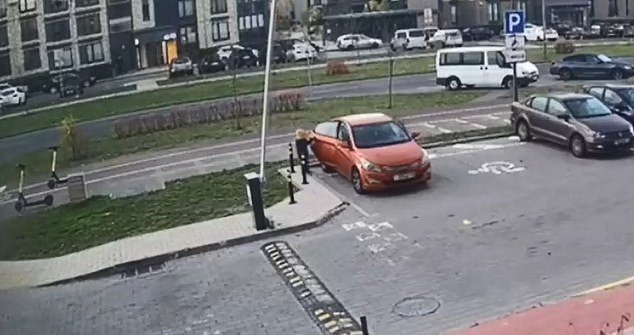 The surveillance camera footage shows a boy standing near the rear passenger door and about to get into the red Hyundai car
