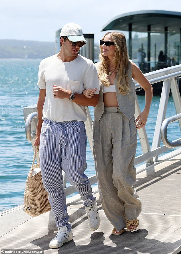 Margot Robbie, 33, showed off her toned midriff in a skimpy bralette and cardigan combo during a romantic boat trip with hubby Tom Ackerley in Sydney's Rose Bay on Friday.  Pictured