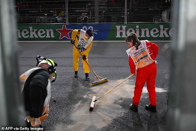 Workers try to clean up an oil leak on the grid just before the Las Vegas Grand Prix