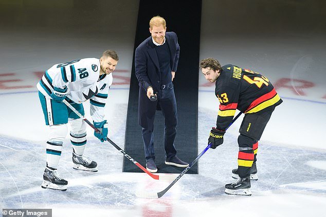 Prince Harry, Duke of Sussex drops the puck during a ceremonial confrontation with Quinn Hughes #43 of the Vancouver Canucks and Tomas Hertl #48 of the San Jose Sharks prior to their NHL game last night