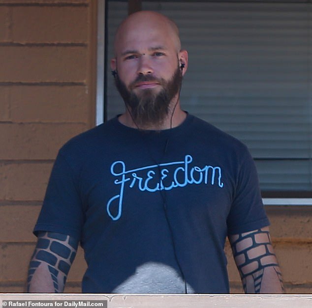 Chansley is seen wearing a Freedom shirt outside a Phoenix shelter in April following his early release from prison