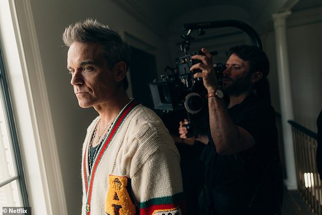 Robbie Williams has opened up about a new Netflix documentary that shows his battle with addiction and mental illness.  Pictured: The hitmaker films the 'Robbie Williams' docuseries