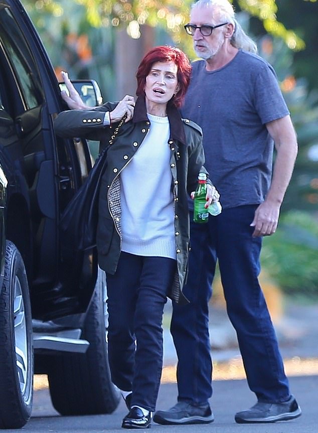 Slim physique: Sharon Osbourne, 71, showed off her slim physique as she arrived at son Jack's home in Los Angeles on Thursday, wearing a white sweater, black jacket, dark jeans and loafers with socks