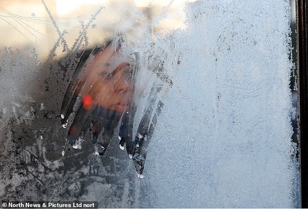 A commuter waits in a frozen bus stop in Low Fell, Gateshead this morning